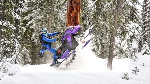 Ski-Doo Freeride 2027 при манёвре с поднятыми лыжами в заснеженном лесу