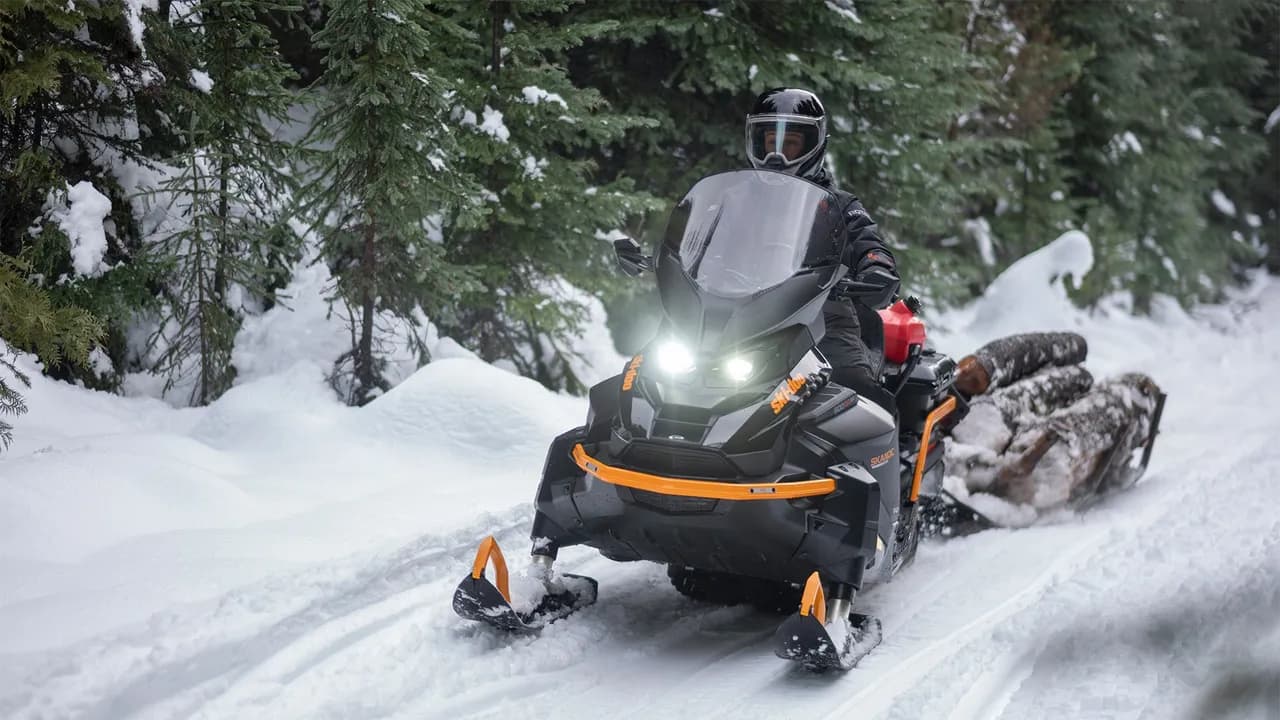 Ski-Doo Skandic LE едет по заснеженной лесной тропе