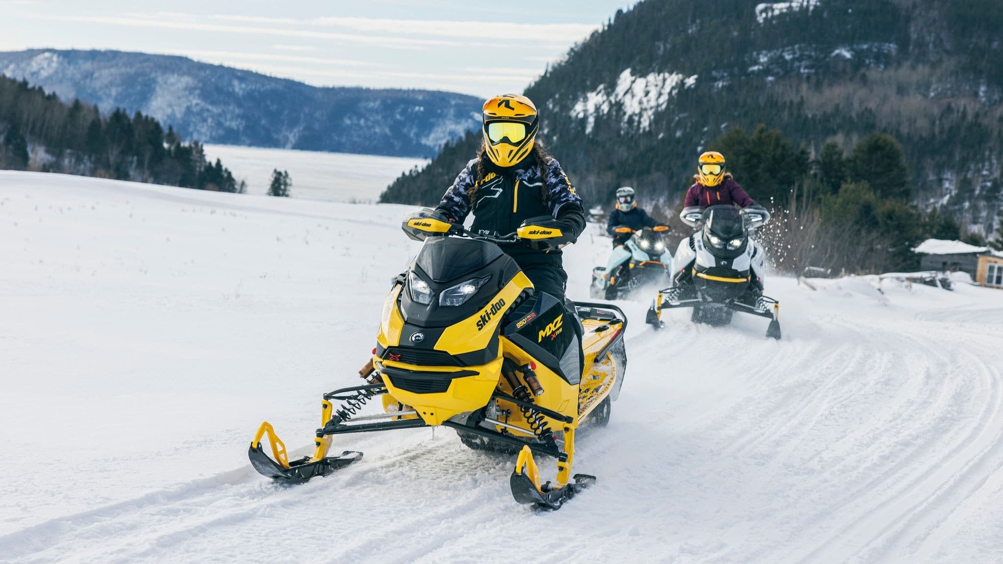 Группа водителей на Ski-Doo движется по зимнему маршруту
