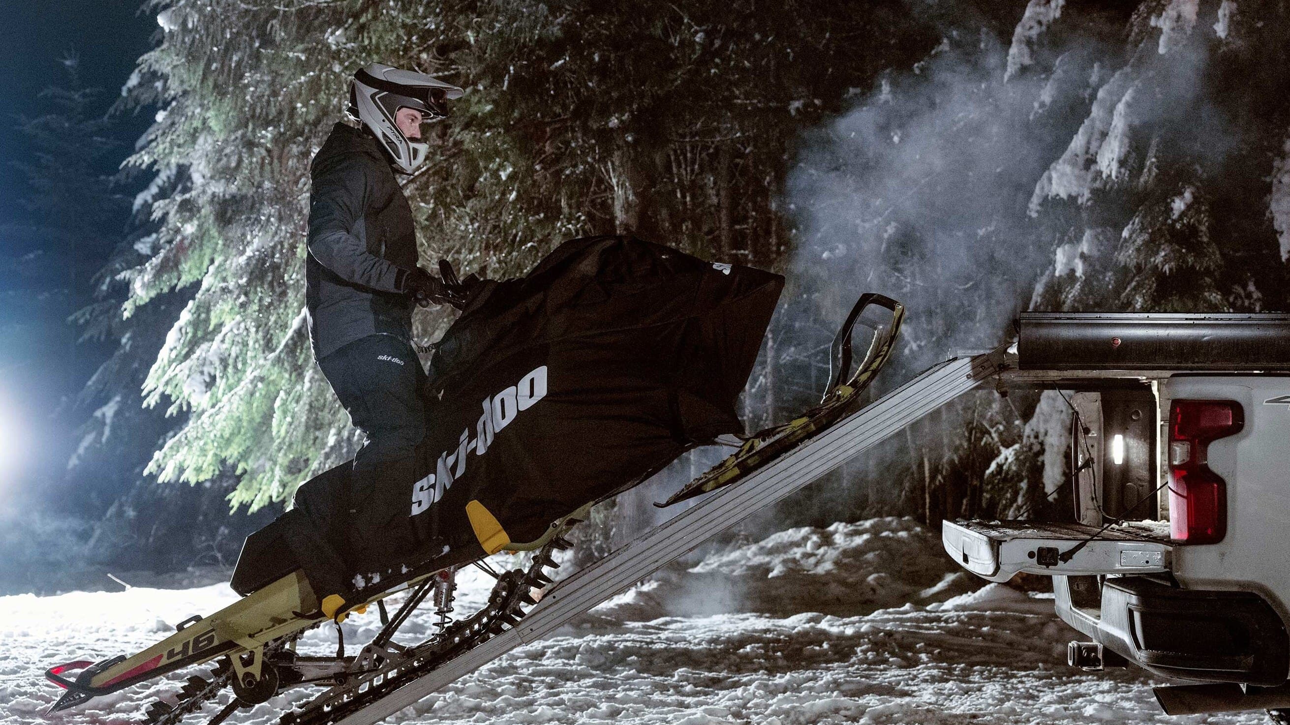 Ski-Doo поднимается по алюминиевой рампе на платформу пикапа