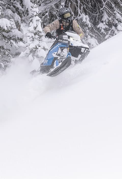 Polaris PRO RMK с водителем в глубоком снегу, модельный год 2027.
