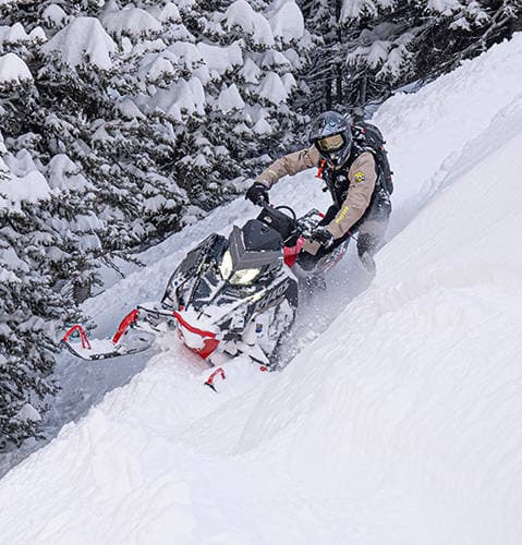 Водитель на Polaris RMK Khaos на заснеженном склоне, модельный год 2027.