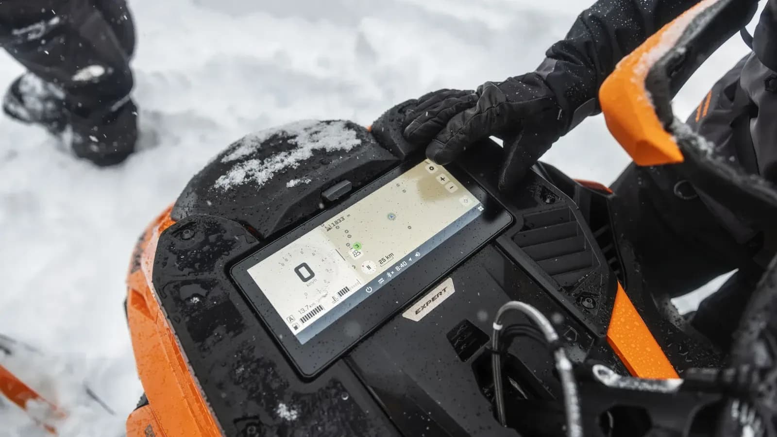 Райдер в перчатках пользуется картой на дисплее снегохода Ski-Doo